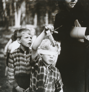 876712 Afbeelding van een jongetje van een club van het Franciscus Liefdewerk in Utrecht, dat het spel 'blindemannetje' ...